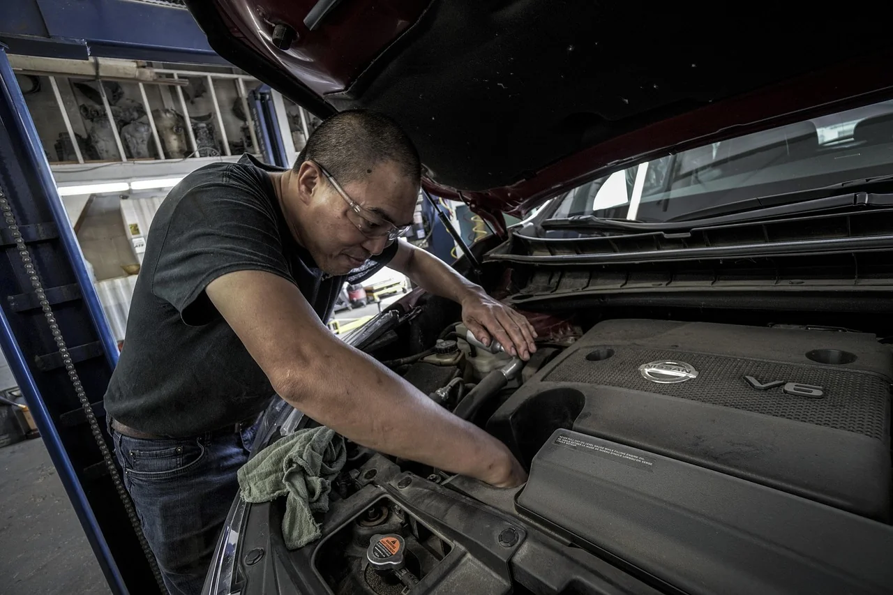 Technician inspecting a vehicle engine bay during a health check