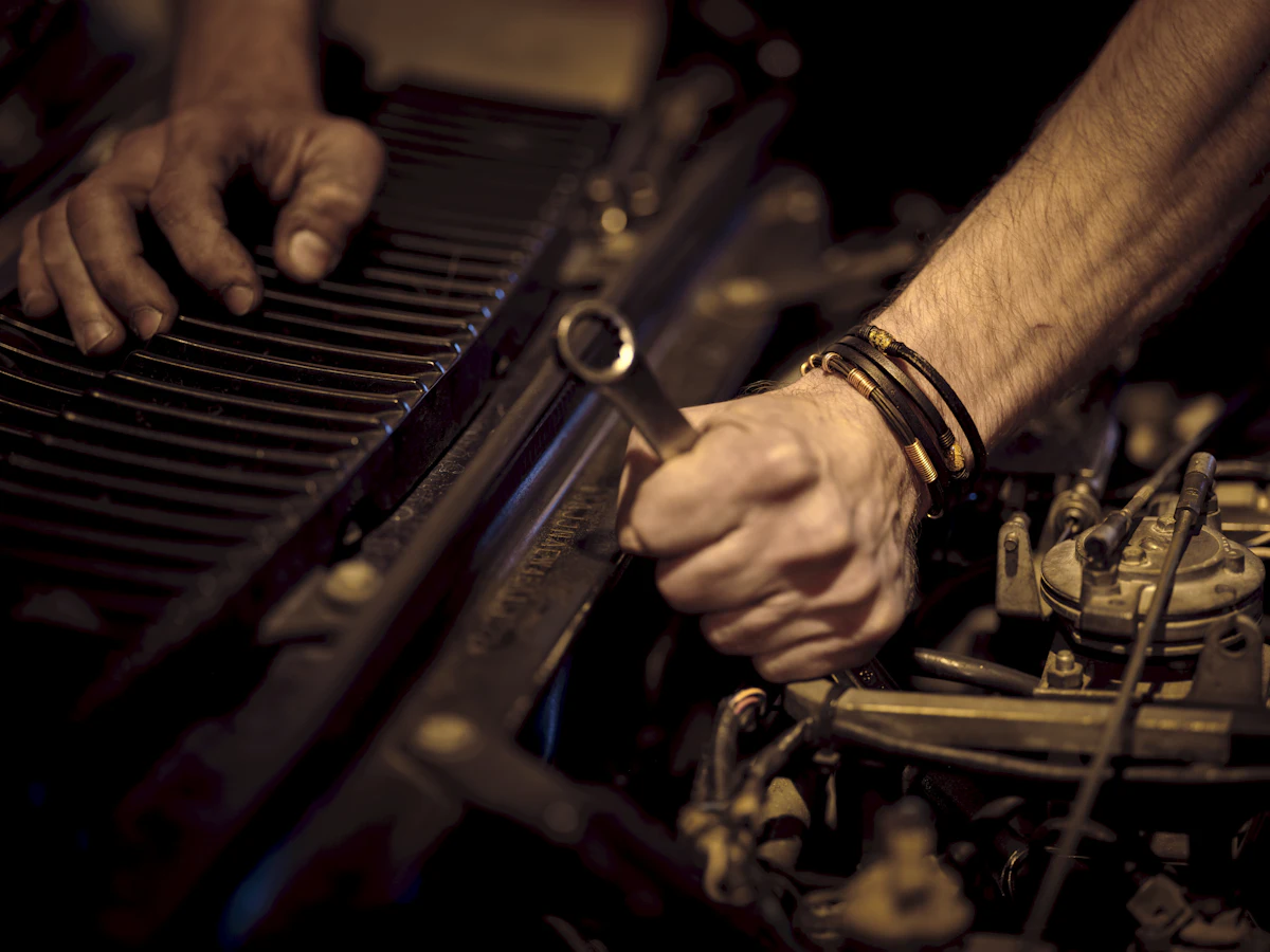 Close-up of a technician's hands using a spanner on an engine